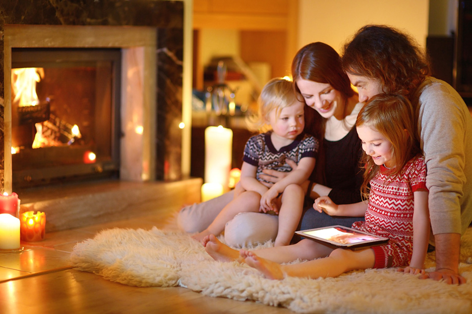 Family spending time together in front of fireplace during the holidays